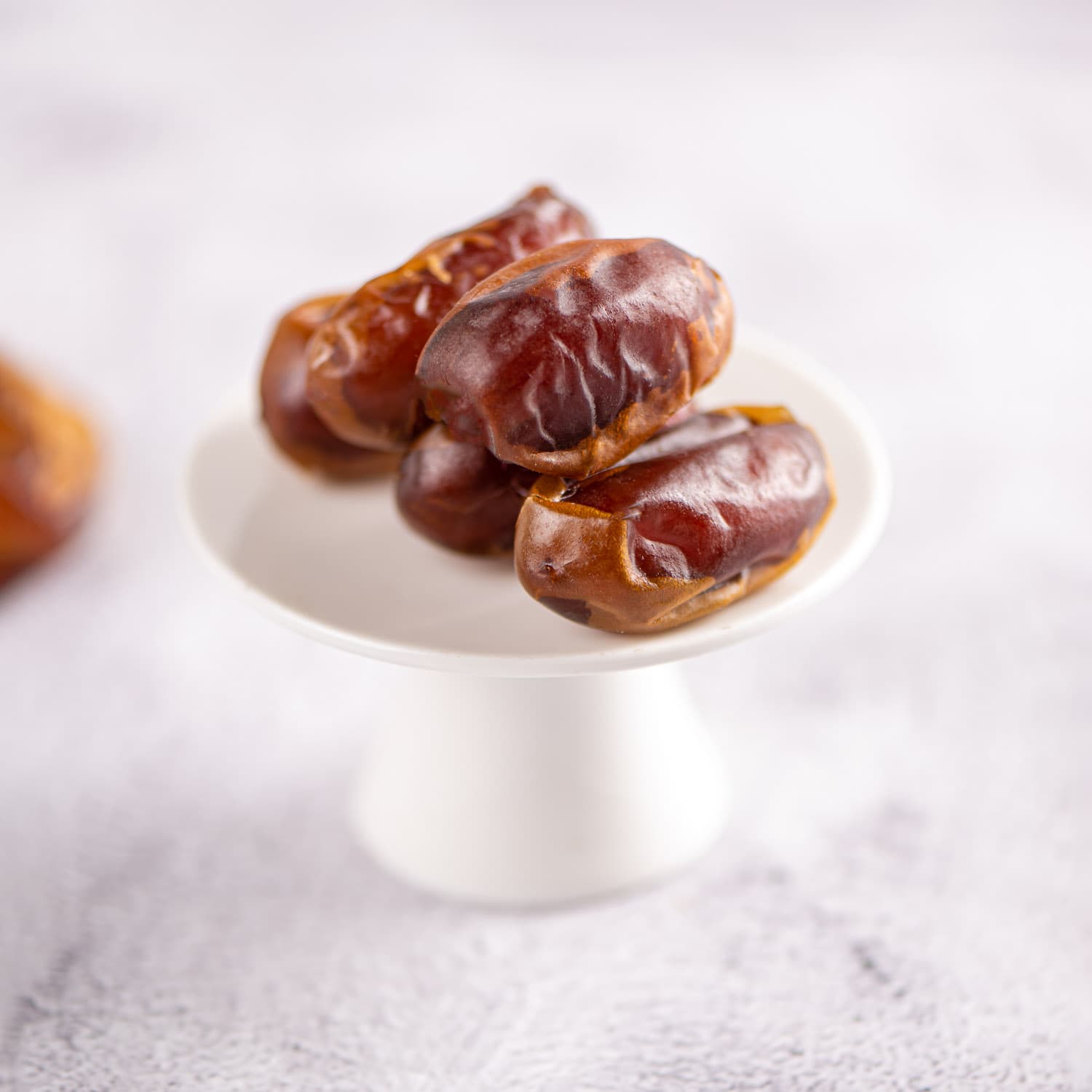 Plain Kholas dates from The Date Room on a white serving stand