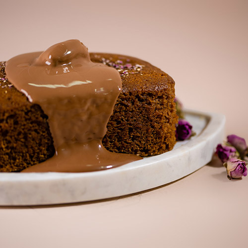 A slice of The Date Room Cake, a moist and luxurious treat filled with premium dates.