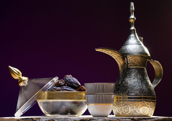 A traditional Emirati setup featuring aromatic Arabic coffee and a plate of fresh dates, embodying the essence of Emirati hospitality and culinary traditions.